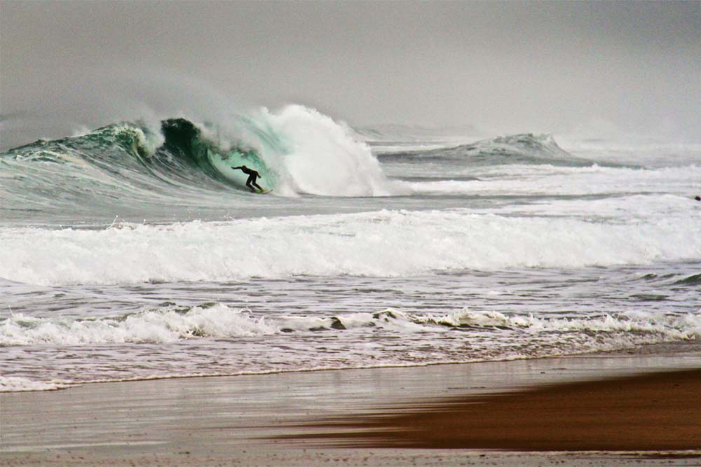 Surfer tucks into a tube at La Piste, Capbreton