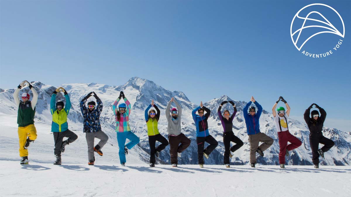Skiers perform the tree pose during a yoga session in the French Alps