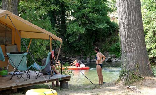 A riverside pitch at the Camping Huttopia Millau