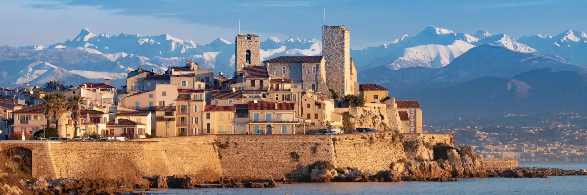 View of the walled city of Antibes with the Alps in the background.