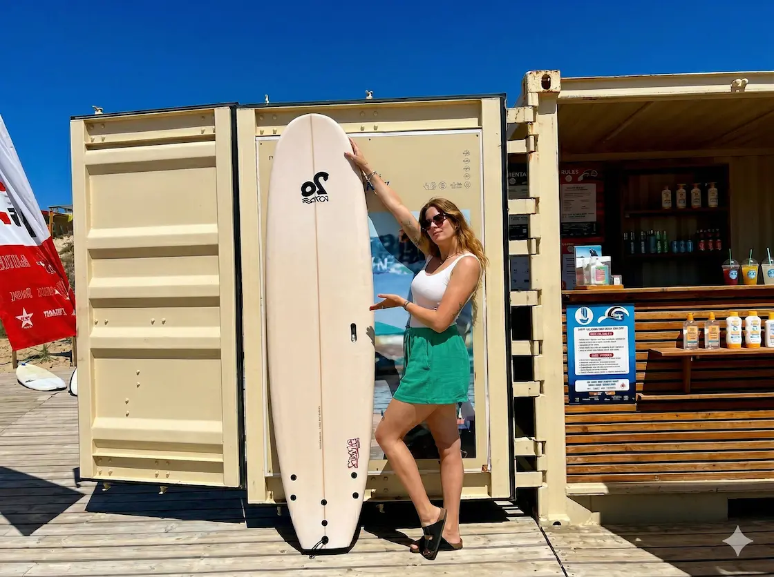 Girl showcasing a 7'6 surfboard for hire in Biscarrosse Plage