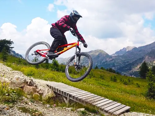 Mountain biker hits a gap jump in Isola 2000