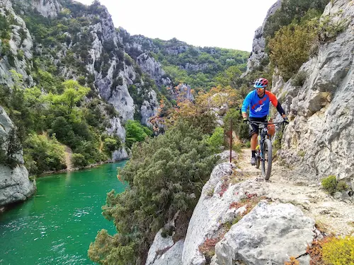 Mountain biker rides a trail overlooking the Verdon river