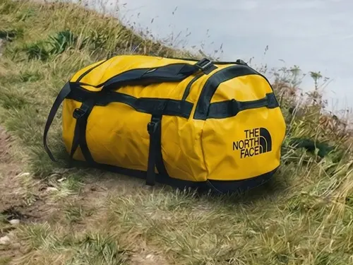 Best Duffel Bags The North Face Base Camp Duffel on a grassy trail in the French Alps